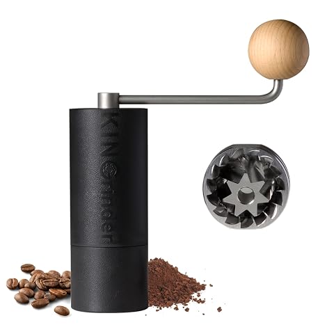 Moulin à café manuel compact noir avec poignée intégrée et brosse de nettoyage sur un plan de travail en bois