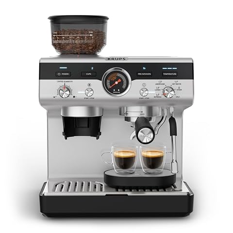 Machine expresso argentée avec broyeur intégré et buse vapeur, posée sur un plan de travail en bois.