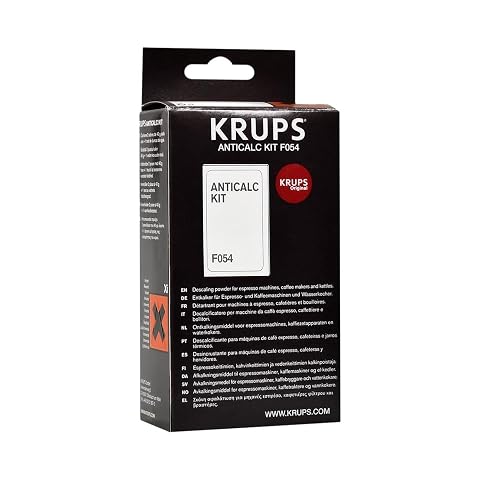 Deux sachets de détartrant Krups et un test de dureté posés sur un plan de travail en bois