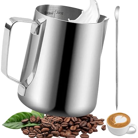 Pichet à lait en inox avec repères intérieurs et stylo latte art posé sur un plan de travail en bois