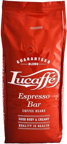 Sachet rouge de café en grains Lucaffé Espresso Bar posé près de quelques grains et d’une tasse crème.